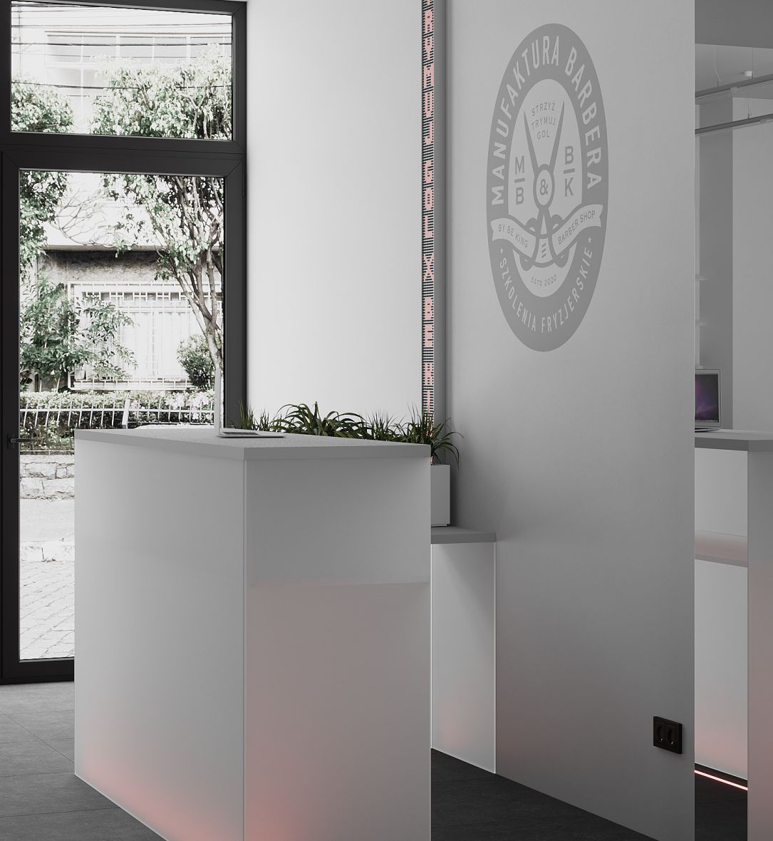 A white reception desk featuring a plant, part of the interior design at Manufaktura Barbera, Krakow, by TenZeroTwo Bureau
