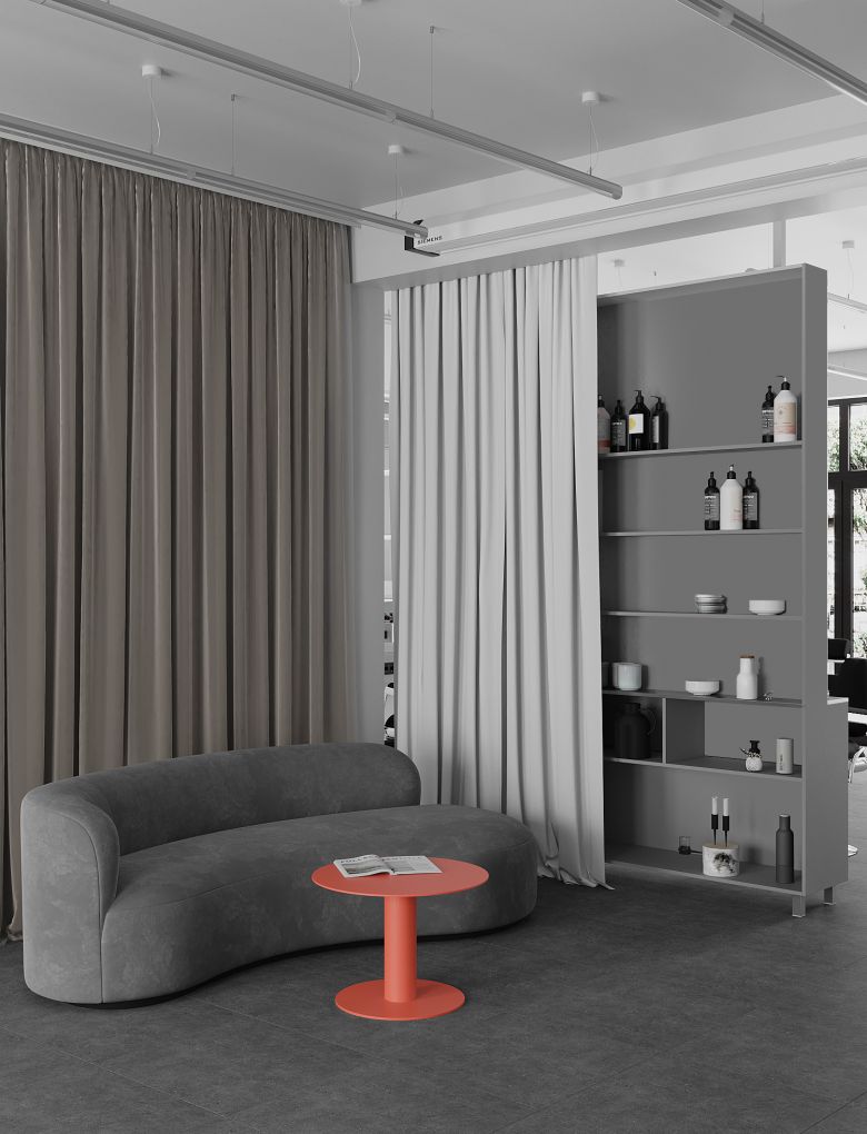 Modern barbershop featuring a grey couch and an orange table, designed by 10:02 Bureau for Manufaktura Barbera, Krakow